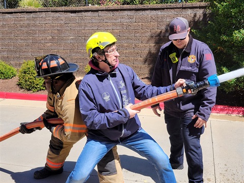 An image of a resident trying their skills with a live fire hose.