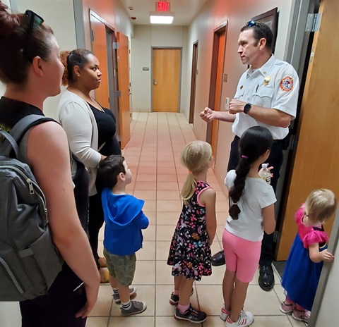 An image of a firefighter giving a behind the scenes tour at the firehouse